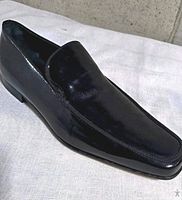 Left side view of both black patent leather loafers