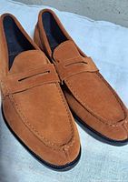 Pair of light brown suede penny loafers top view