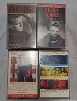 Four cassettes: Corey Hart Young Man Running, Bryan Adams Reckless, Bruce Springsteen Born in the U.S.A., The Police Synchronicity