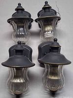 Four black outdoor wall lanterns with glass shades