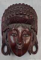 Front view of carved wooden face wall pocket showing details of carving and finish