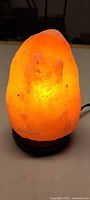 Illuminated Himalayan salt lamp on wooden base