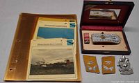 Aircraft cards in plastic sleeves alongside insignia items