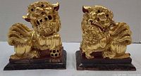 Front view of both gold Foo Dog figurines on bases