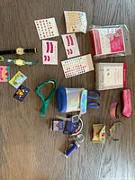 Assorted small accessories including watches, sticker sheets, holographic tote, headbands, purses, microphone, passes