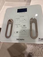 Triomph digital scale showing brand mark and sensor pads