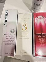 Three boxed products: Shiseido White Lucent Spot Corrector, Beautycounter No.3 Balancing Charcoal Facial Mask, Shiseido Ultimune Concentrate