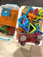 Overview of two bins containing assorted Magformers tiles and wheeled base