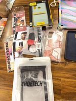 Various phone cases, screen protectors, Choetech pouch, pop sockets on table