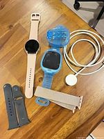 Lot overview: both smartwatches, charging cable, straps, shell