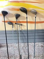 All six clubs lined up showing varying head shapes and shaft lengths