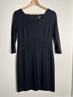 Front view of black 3⁄4 sleeve V-neck dress on hanger