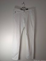 Full front view of white jeans hanging
