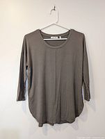 Front view of olive Babaton 3/4 sleeve top on hanger