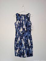 Front view of abstract patterned sleeveless dress hanging on hanger