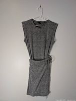 Full view of gray dress on hanger showing overall design and waist tie