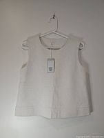 Front view of cream COS top on hanger