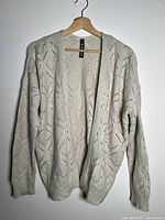 Front view of cream open-knit Design Lab cardigan on hanger