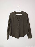 Front view of olive cotton blouse on hanger