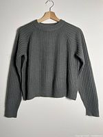 Front view of grey ribbed sweater on hanger