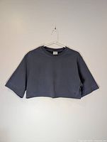 Front view of cropped blue Gymshark T-shirt on hanger