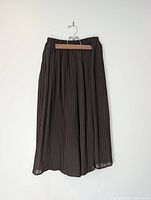Front view of olive green pleated capri pants on hanger