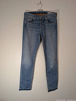 Full view of Rag & Bone light blue denim jeans hanging