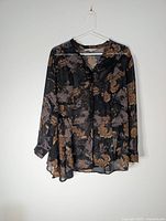 Front view of Cleo Petites sheer floral blouse on hanger