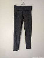 Full view of gray herringbone leggings hanging