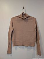 Front view of dusty pink turtleneck sweater on hanger