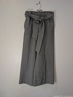Front view of grey micro-check wide-leg capri pants hung on hanger
