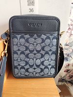 Front view of Coach blue Sullivan crossbody bag showing signature C canvas and leather trim