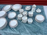 Full view of assorted plates, bowls, cups, covered dish, creamer, sugar and gravy boat