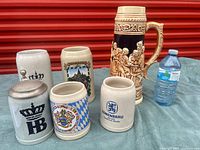 Group shot of all six steins showing size variation and logos