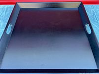 Top view of dark brown square wooden tray showing interior surface and cut-out handles