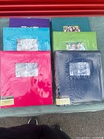 Six sealed colour photo albums on table