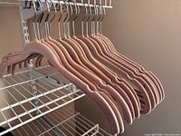 Row of tan velvet hangers on wire shelf