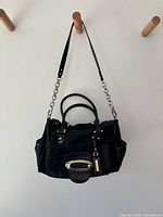 Full view of Guess black satchel hanging