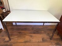 Full view of Ikea Torsby dining table, white glass top, chrome legs