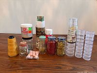 Full lot view showing adhesives, glitter jars, thread cone, fastener jars, bead heads, storage containers, washi tape