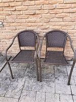 Pair of brown resin wicker armchairs front view