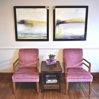 Front view of both rose velvet armchairs with small table between