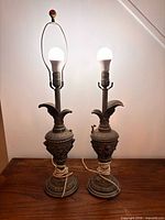 Pair of illuminated urn lamps showing size, patina, one red finial