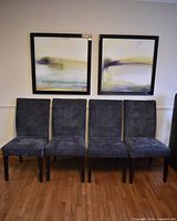 Front view of four matching charcoal grey tufted dining chairs side by side