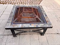 Overall view of square slate tile fire pit with mesh spark guard