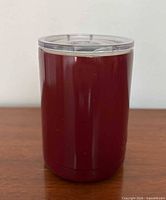 Front view of deep red Swig insulated tumbler standing upright