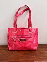 Front view of bright pink croc-embossed tote with straps visible