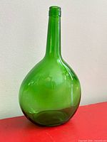 front angled view of bulbous green glass bottle