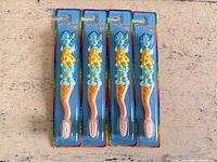 Four identical blister-packed Care Bears toothbrushes on table
