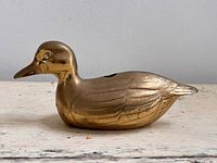 Left profile of brass duck figurine